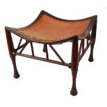 A large Mahogany Thebes Stool by Liberty and Co, London with leather upholstered dished seat, raised