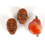 AN AGATE PENDANT TOGETHER WITH TWO CARVED OLIVE NUTS
19th  / 20th Century
The agate formed as a