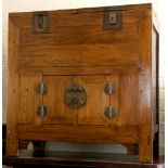 A Chinese rice chest, two lift up blocks, brass latches, over double door cabinet with brass