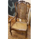 A late 19th century ratan chair, mahogany frame with floral and scroll carving, scroll arms with