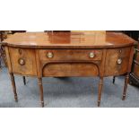 A Georgian mahogany bow fronted sideboard with drawers flanked by cupboard raised on turned legs,