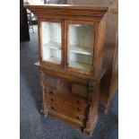 A Victorian pine based miniature dresser having three drawers and glass glazed top