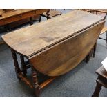 A 17th century oval leaf gate leg dining table with one end drawer raised on turned legs joined by