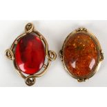 A 19th century gilt metal mounted red amber brooch and another (2)