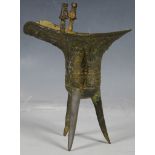 Chinese bronze jue wine vessel, archaic dragon decoration and handle, tri-splay legs, 19cm high