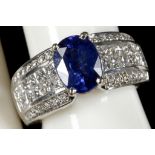 A sapphire set ring with diamond cluster shoulders