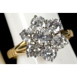 A diamond seven stone cluster flower shaped ring in yellow gold shank