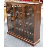 A mahogany floor standing glazed bookcase, shaped plinth and bracket, 123 x 123 x 34cm