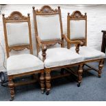 A pair of oak upholstered dining chairs with carved shell back rail, above an overstuffed seat,