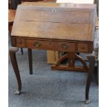 An antique oak full front bureau, with frieze drawer and raised square section cabriole leg with