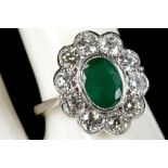 An emerald and diamond set cluster ring