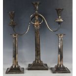 A pair of Sheffield plate octagonal section candlesticks on square base, and a three silver plated