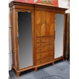 An Edwardian breakfront satinwood and cross banded triple wardrobe; the central section with