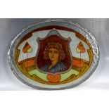 An Art Nouveau period leaded oval shaped stained glass panel, centrally decorated with portrait