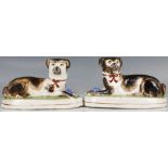 A pair of unusual 20th century Staffordshire pottery models of seated dogs, painted in