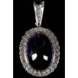 An amethyst cabouchon pendant with diamond border