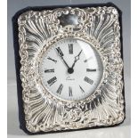 A Victorian style hallmarked silver cased free standing desk clock, embossed with scrolling border