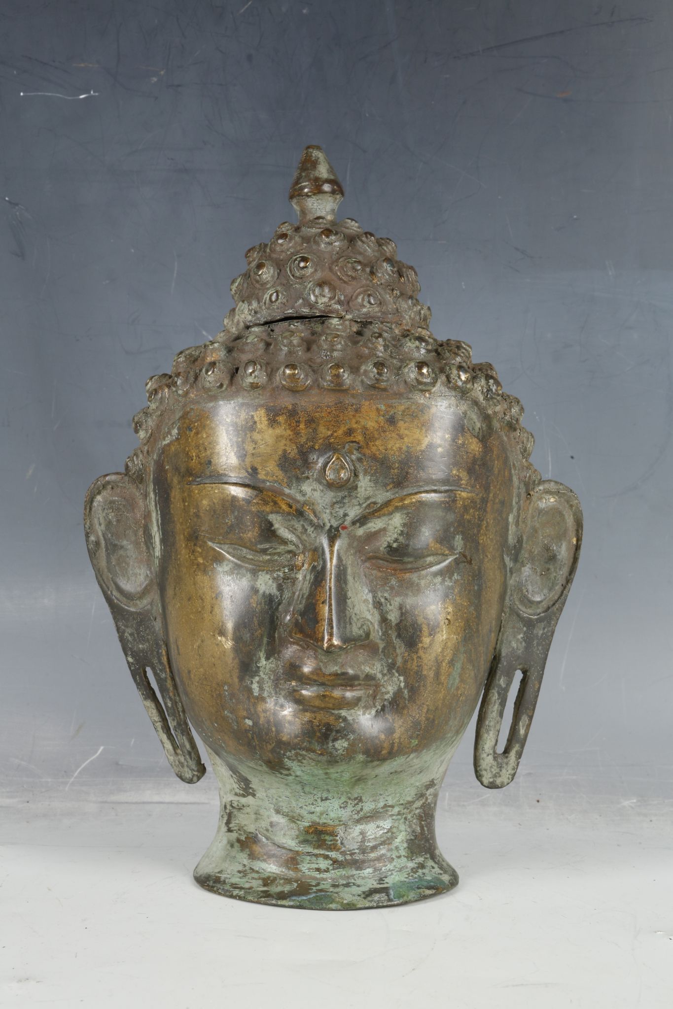A 19th century Tibetan bronze Buddha's head, 28cm high