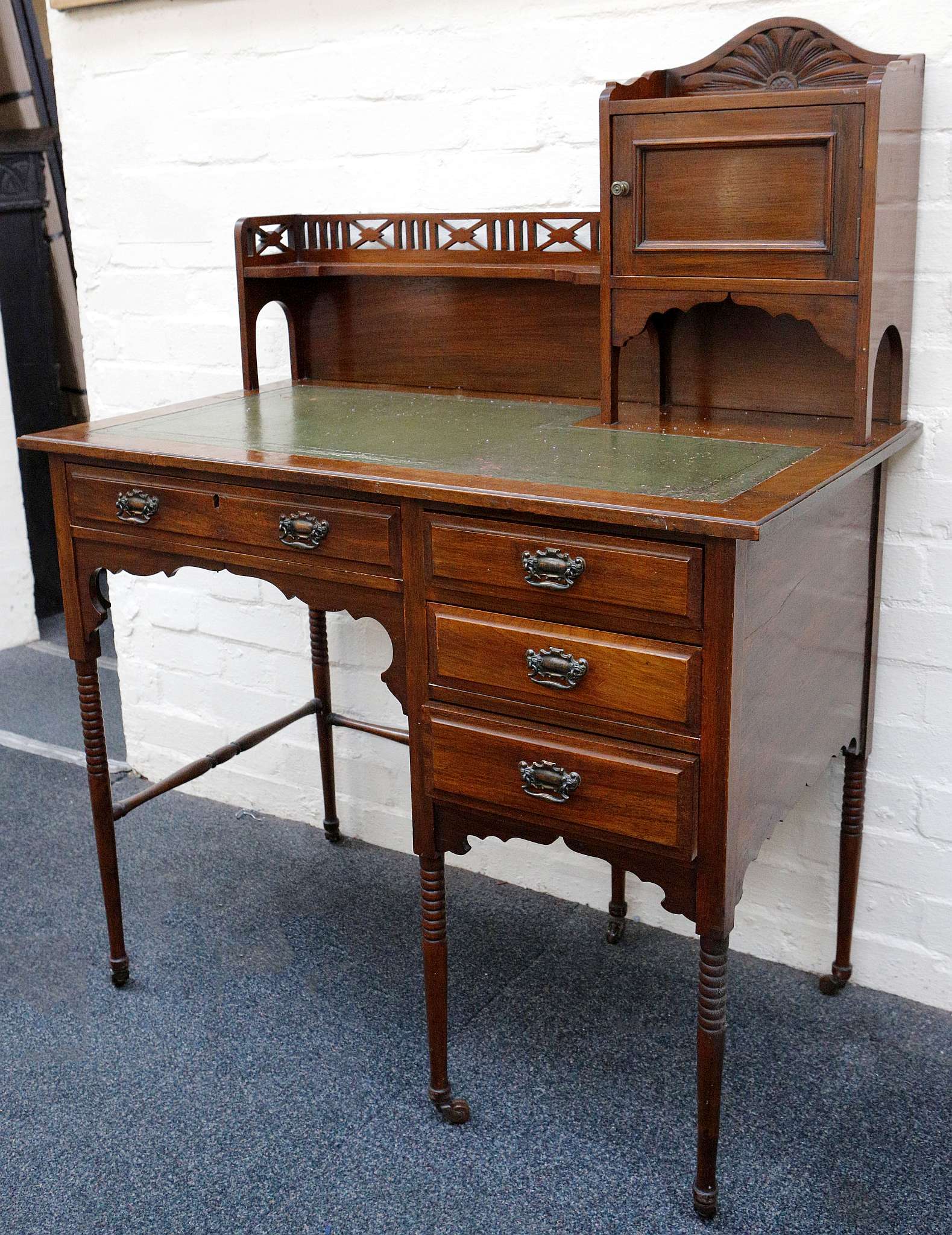 An Edwardian ladies desk, walnut with green leather insert with gilt tooling, petal carving to