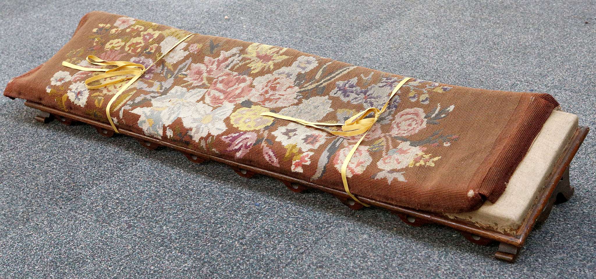 A Victorian rosewood long footstool, pierced supports and apron, woolwork cover, loose