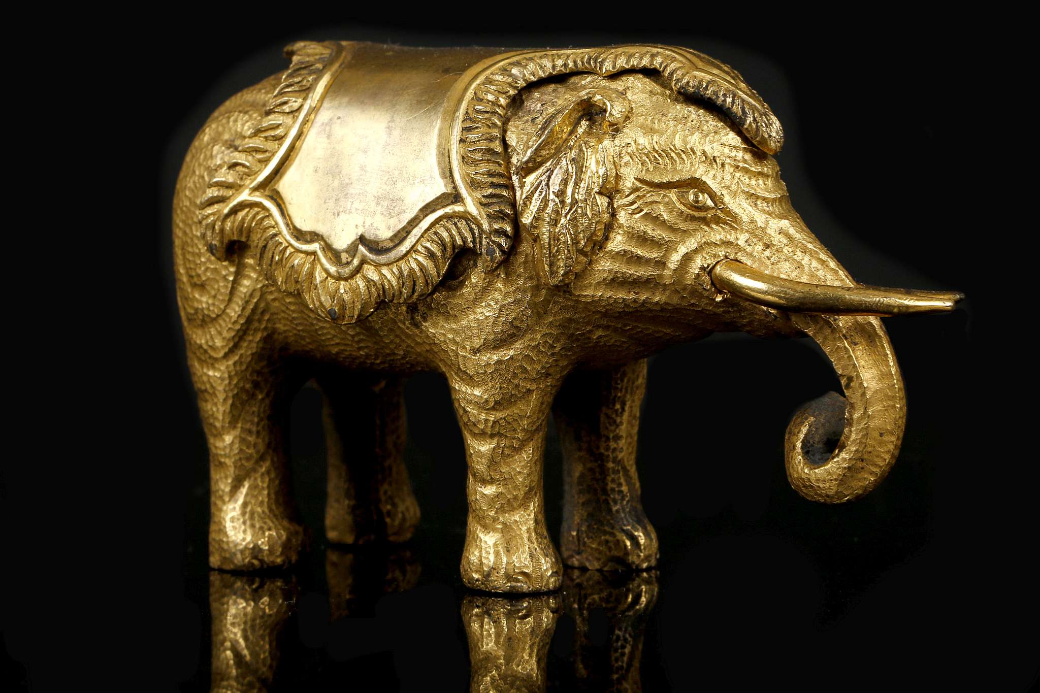 A CHINESE GILT BRONZE ELEPHANT PAPERWEIGHT.  Qing Dynasty, Qianlong era. Standing four-square with