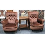 A pair of Edwardian button upholstered armchairs raised on turned legs