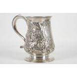 A late Victorian hallmarked silver tankard, embossed with foliage decoration raised on circular