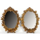 A pair of gilded iron oval wall mirrors with mould