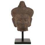 A KHMER SANDSTONE MALE HEAD. Koh Ker style, 2nd quarter of 10th Century. With a benign face, the