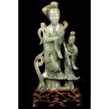 A CHINESE JADEITE CARVING OF A GUANYIN AND ATTENDANT. Wearing a long layered robe falling in