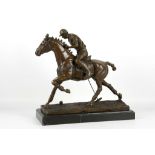 A bronzed sculpture of a gentleman playing polo on