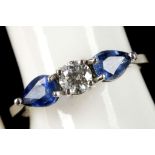 An 18ct white gold, diamond and sapphire three stone ring, the central 0.25ct diamond flanked by