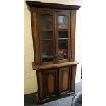 A small early Victorian mahogany bookcase with twin glazed doors over a cupboard base, distressed