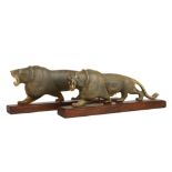 A PAIR OF INDIAN CARVED HORN LIONS. Mounted on wooden bases, 21.5cm long.