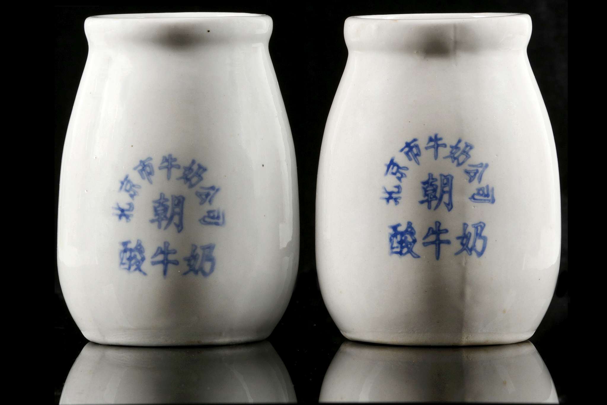 A PAIR OF CERAMIC MILK BOTTLES.  Mid 1960s.  Thickly potted, with a swelling body, a thick neck