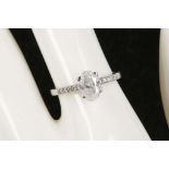 A 14k white gold and diamond solitaire ring, the oval stone flanked by diamond shoulders, diamond: