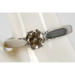 A 14k white gold and diamond solitaire ring, claw set with a 0.73ct brilliant round cut stone