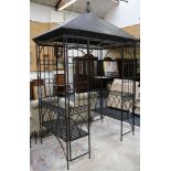 A large ornamental metal gazebo, painted black with a tin roof