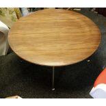 A modern circular section walnut low table, raised on chrome metal legs