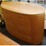 An Art Deco style oval chest of four long graduated drawers, raised on a plinth base, together