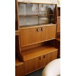 a 1970 G Plan cabinet with glazed sliding doors over cupboard doors and open recess, raised on stile
