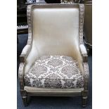 A pair of carved show wood armchairs, upholstered in a gold material with contrasting cushion,