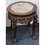 A Chinese padouk wood, marble topped pot stand with carved frieze, temple lion legs and claw and