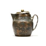 A TIBETAN MONASTIC COPPER JUG AND COVER. c. 17th Century. The body with beaten floral and