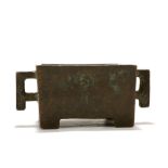 A CHINESE BRONZE RECTANGULAR CENSER. Resting on four integral corner supports and flanked by a