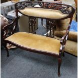 An Art Nouveau twin seat, carved whiplash decoration, later velour back and seat, scroll arms,