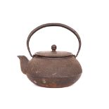 A JAPANESE IRON KETTLE. 20th Century. With sloping shoulders the body covered with a raised