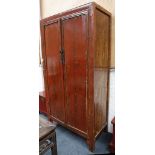 A large Chinese red lacquered elm cabinet. Qing Dynasty. The interior divided into three shelves and