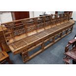 A large and impressive Chinese elm wood bench, the back carved in openwork with panels of animals