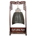 A CHINESE BRONZE BELL WITH WOODEN STAND. Ming. The bell  of lenticular form, with a central panel